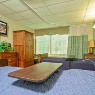 A cozy bedroom with wooden furniture and a large window.