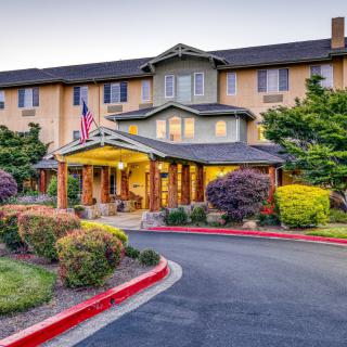 The entrance to a well-lit hotel with landscaped surroundings.