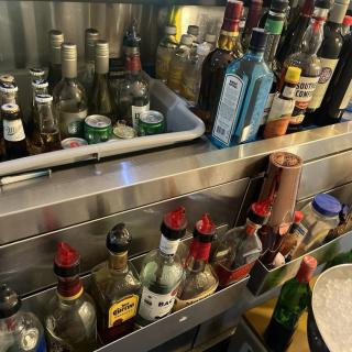 A variety of liquor bottles arranged on a bar shelf.