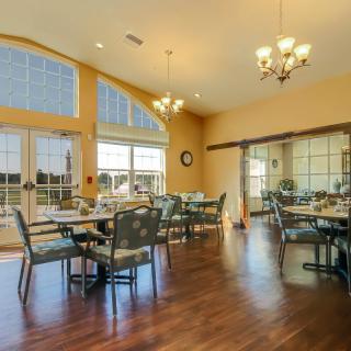 A spacious dining area with large windows and elegant chandeliers.
