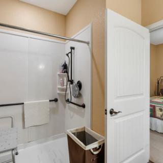 A modern bathroom featuring a glass shower enclosure and neatly organized space.