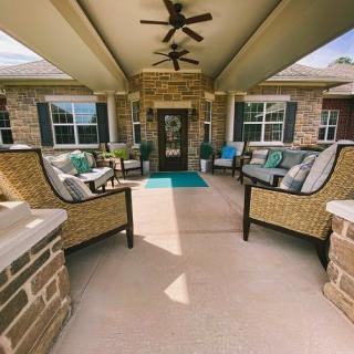 A cozy, covered patio area with comfortable seating and ceiling fans, perfect for outdoor relaxation.