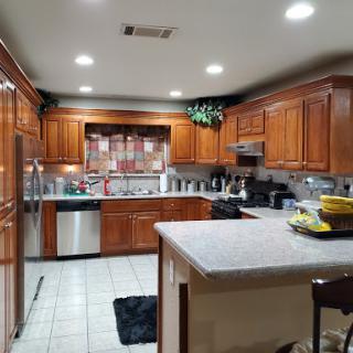 A modern kitchen featuring wooden cabinets and stainless steel appliances.