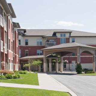 A modern retirement home with a welcoming entrance and landscaped surroundings.