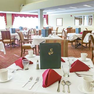 A well-set dining room with elegant table arrangements and a cozy ambiance.