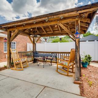 A cozy backyard pergola featuring wooden rocking chairs and a bench under a rustic structure.