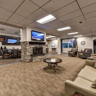 A spacious lobby with comfortable seating, a fireplace, and multiple televisions.