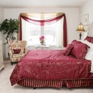 A cozy bedroom with red bedding and elegant decor.