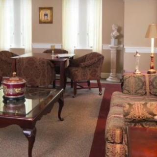 A classic-style living room with elegant furniture, featuring a sofa, a coffee table, and soft lighting.