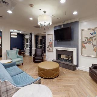 A modern living room with cozy seating, a fireplace, and a mounted television.