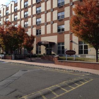 A brick apartment building with autumn trees lining the street.