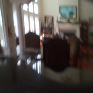 A blurry view of a living room with furniture, large windows, and a fireplace.