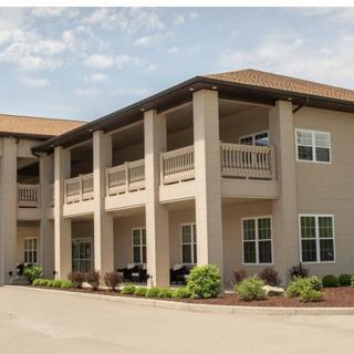 A two-story apartment building with balconies and landscaped surroundings.