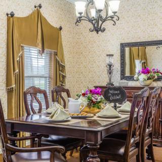 Elegant dining room with a set table and floral centerpieces.