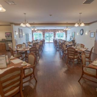 An empty restaurant dining area with neatly arranged tables and chairs.