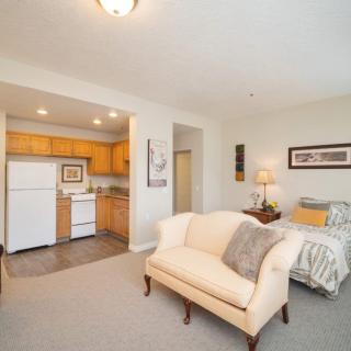 A cozy studio apartment with an open-concept design, featuring a living area, small kitchen, and bedroom.