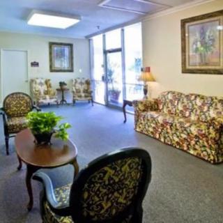 A cozy waiting room with floral-patterned furniture and a glass entrance.