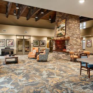 A spacious and modern lobby featuring a stone fireplace and comfortable seating.