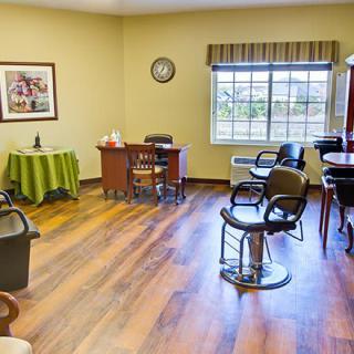 A cozy salon interior with chairs, mirrors, and a wooden floor.