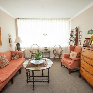 A cozy living room with a sofa, armchair, and coffee table set near a large window.