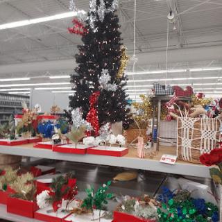 A festive display of Christmas decorations, featuring a decorated tree and various holiday-themed items on a shelf.