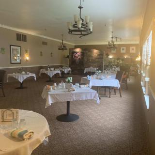 A cozy restaurant dining area with elegantly set tables and soft lighting.