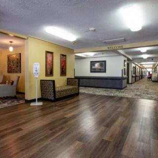 A spacious hallway with wooden flooring, decorated with artwork and furniture.