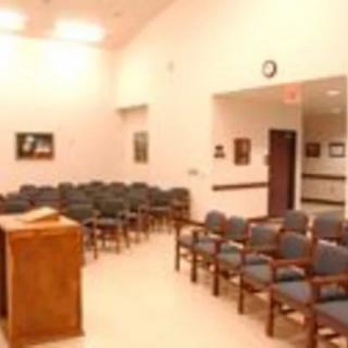 An empty meeting room with arranged chairs and a podium.