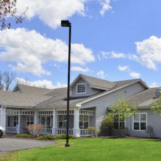 A suburban residential building with a well-maintained lawn and a clear sky in the background.