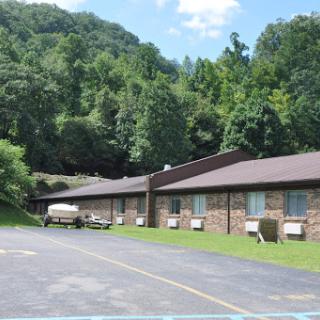 A serene view of a building nestled in a lush, green landscape.