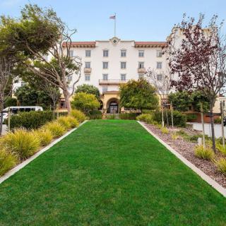 A well-maintained lawn and landscaping leading up to a grand hotel entrance.