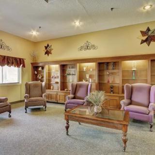 A cozy living room with armchairs, bookshelves, and decorative elements.