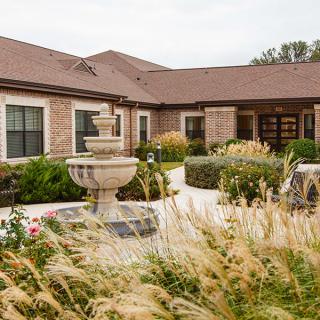 A charming building with a central fountain and well-maintained garden.