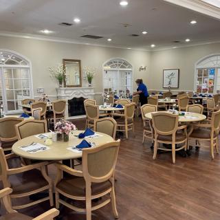 A well-lit dining room with neatly arranged tables and chairs.