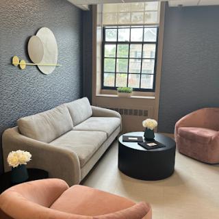 A stylish and modern living room setup featuring a cozy sofa, elegant chairs, and a sleek coffee table.