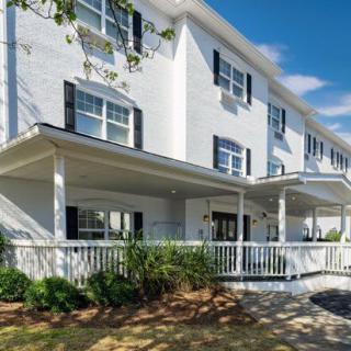 A modern residential building with a spacious porch and multiple windows.