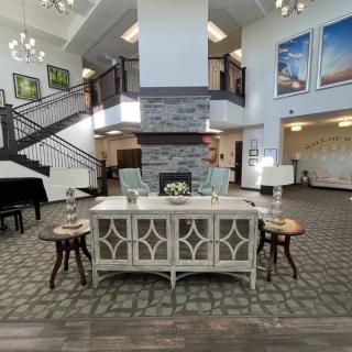 A beautifully designed lobby featuring elegant furniture, a staircase, and artistic wall decorations.