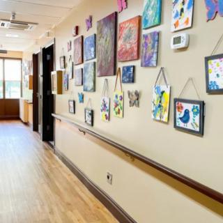 A hallway adorned with various paintings and artwork displayed on the walls.