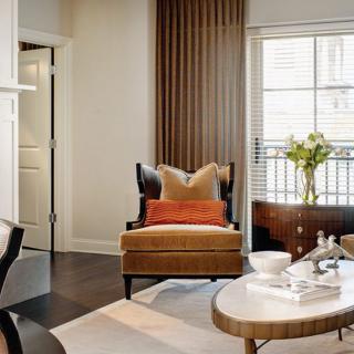 A stylish and cozy living room with modern furnishings, featuring an inviting armchair, coffee table, and decorative accents.