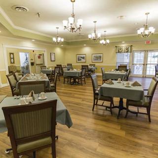 An elegant dining room setup with neatly arranged tables and chairs, ready for guests.