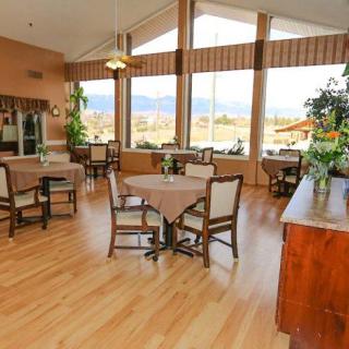 A spacious dining area with tables and chairs, featuring large windows that provide a bright and inviting atmosphere.