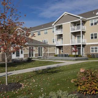 A modern apartment complex with well-maintained landscaping and balconies.