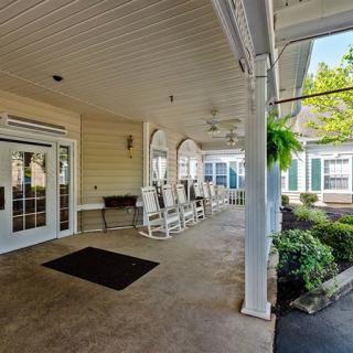 A cozy outdoor porch with rocking chairs and lush greenery.