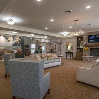 A cozy and spacious living room with comfortable seating, a fireplace, and a television.