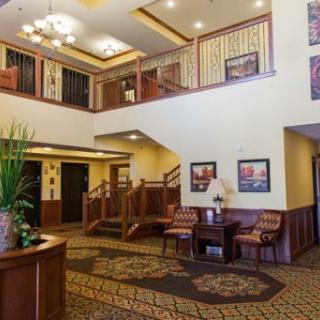 A welcoming hotel lobby featuring elegant wooden decor, comfortable seating, and bright lighting.