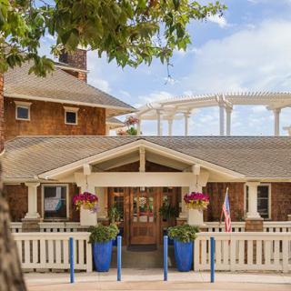 A charming house with a welcoming entrance adorned by blue planters and colorful flowers.