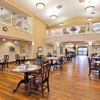 A spacious dining area with elegant tables and chairs, featuring wooden flooring and modern lighting.