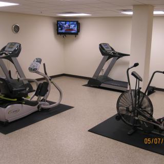 An indoor gym with treadmills, an elliptical machine, and a stationary bike.
