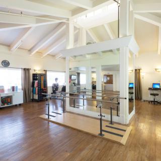 A spacious and modern open-plan interior with wooden flooring and large windows.