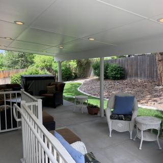 A cozy backyard patio with seating and a covered area.